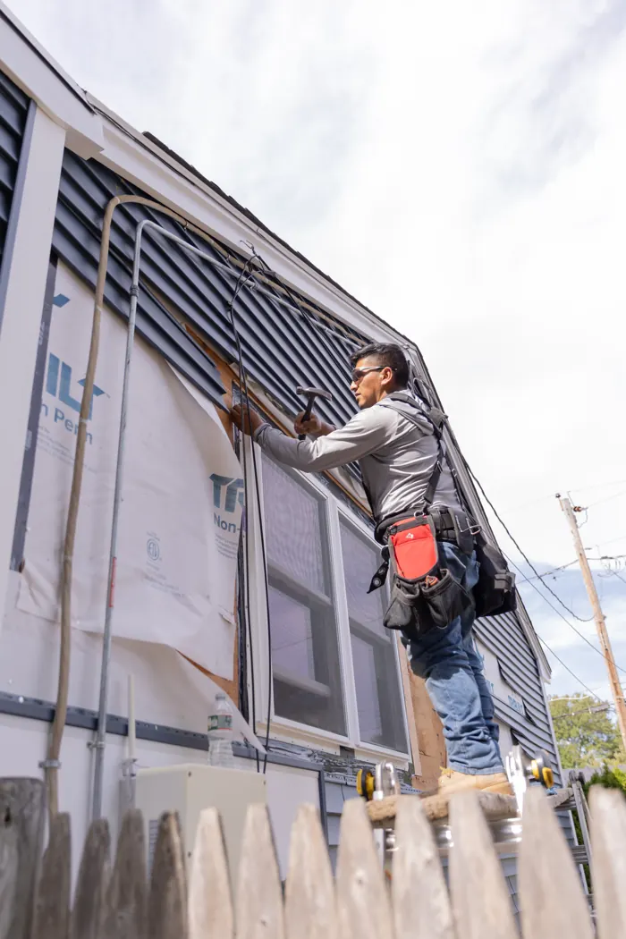 Installer fitting siding panels on a wall