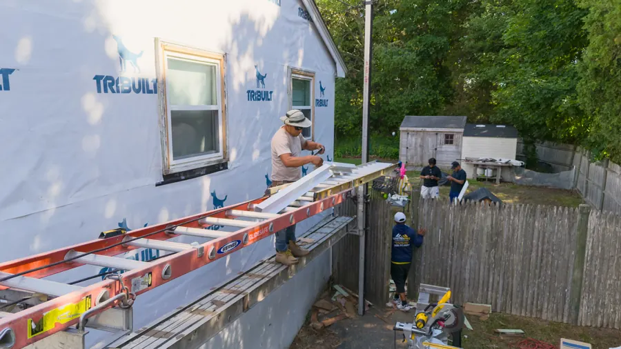Siding installation with house wrap and ladders