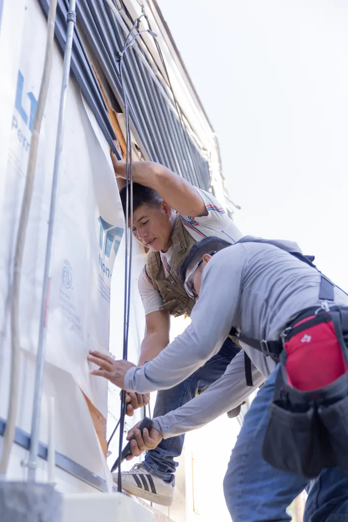 Crew wrapping a house before siding